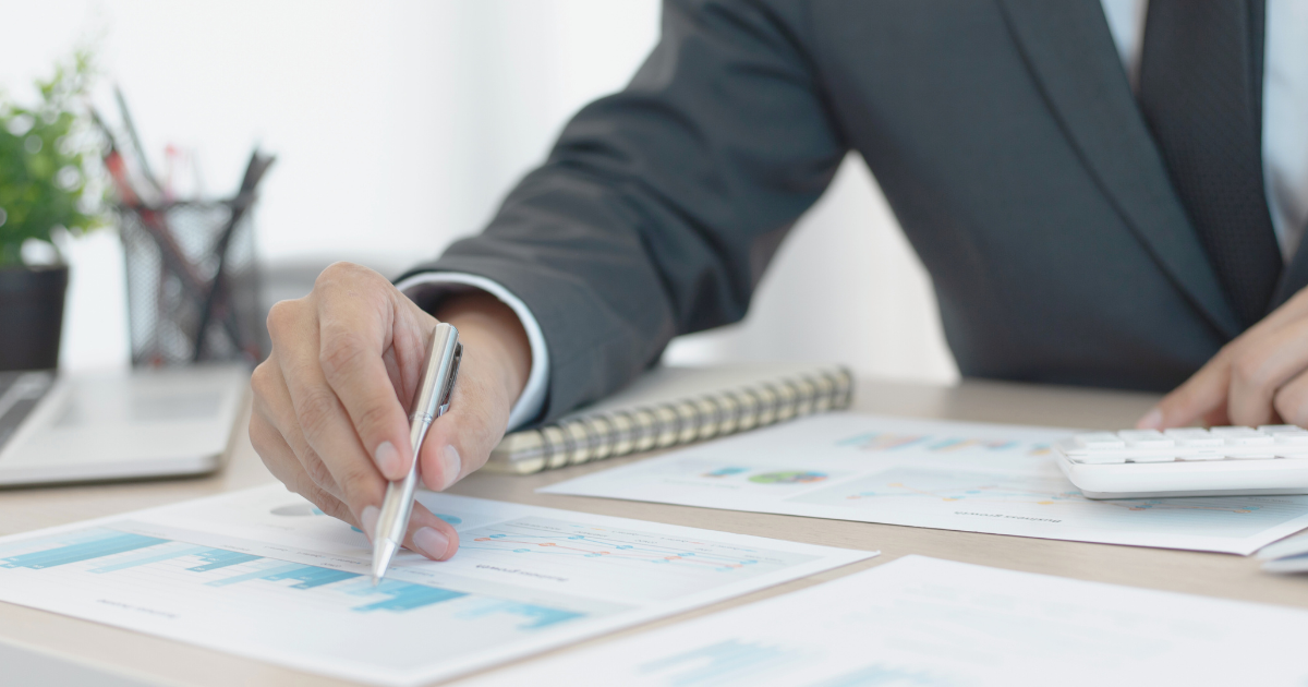 A photograph of a person with a pen sitting at a desk looking over the unique benefits in their MedTech job package.