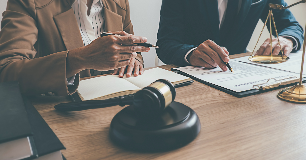 Photograph of a man and woman looking at documents with a gavel to illustrate the passing of the Secure Act 2.0.